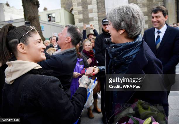 British Prime Minister Theresa May fist bumps a member of the public as she greets people after visiting the scene where former Russian intelligence...