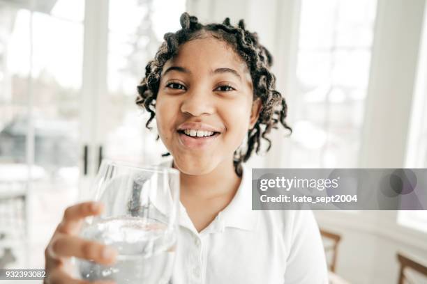 wasserverbrauch und kinder - african girl drinking water stock-fotos und bilder