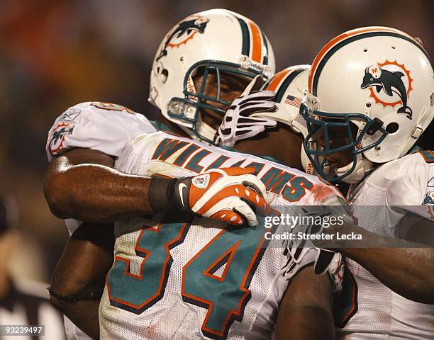 Ricky Williams of the Miami Dolphins celebrates with teammates after he scored on a 14 yard touchdown reception in the second quarter against the...