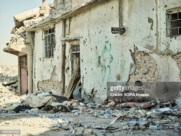 An Iraqi soldier rests in the middle of a street in the Old City. The city of Mosul in northern Iraq has been under Islamic State militants control...