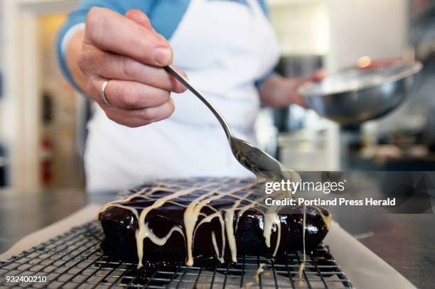 Stacy Cooper puts an Irish Cream Drizzle made with confectioners sugar and Irish Cream liqueur on the beer brownies at Biscuits and Company in...