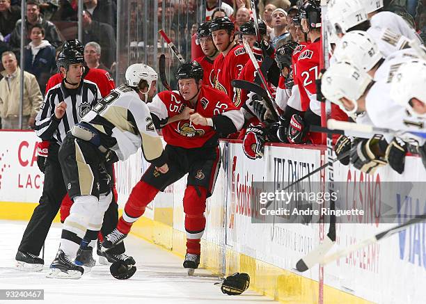 Chris Neil of the Ottawa Senators braces himself against the boards during a fight with Eric Godard of the Pittsburgh Penguins at Scotiabank Place on...