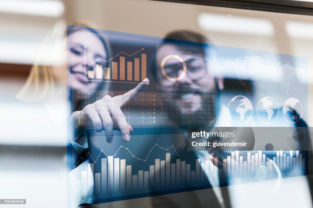 Busines couple discussing business profit on a modern interface