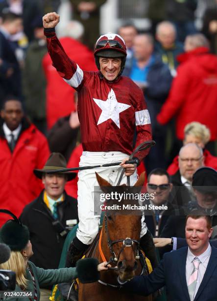 Davy Russell celebrates on Balko Des Flos as they are lead into the winners enclosure after victory in the Ryanair Chase at Cheltenham Racecourse on...