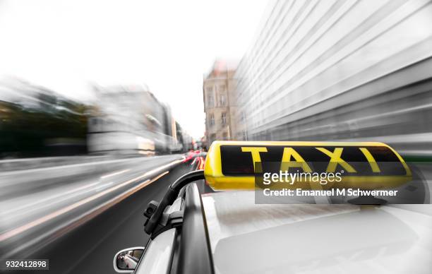 taxi drives through the city of berlin - taxi sign prominent in foreground - taxi sign stock pictures, royalty-free photos & images