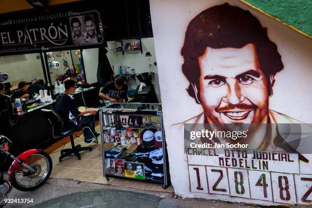Portrait artwork, depicting the drug lord Pablo Escobar, is seen painted on the wall next to a barber shop in the Pablo Escobar neighborhood in...