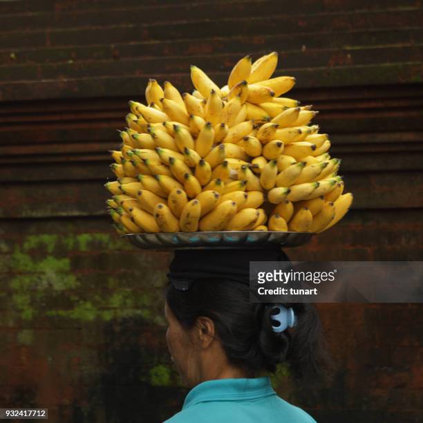 woman selling bananas at tirta empul hindu balinese temple - tirta empul temple stock pictures, royalty-free photos & images