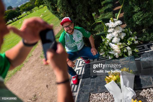 Young Colombian men take snapshots of themselves while visiting the tomb of the drug lord Pablo Escobar at the cemetery of Montesacro, in Itagüí,...