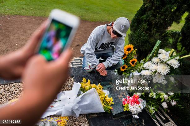 Young Colombian men take snapshots of themselves while visiting the tomb of the drug lord Pablo Escobar at the cemetery of Montesacro, in Itagüí,...