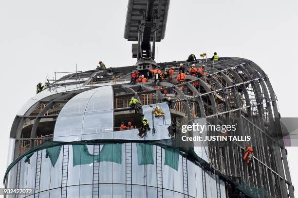 Construction work continues on the roof of One Blackfriars, also known as the Vase, where workers are installing large glass panels onto the exterior...