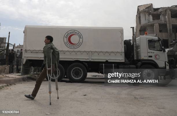 Syrian amputee walks past a Syrian Arab Red Crescent lorry after a humanitarian convoy arrived in the rebel-held town of Douma in Eastern Ghouta...