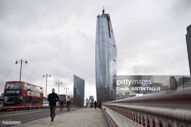 Construction work continues on the roof of One Blackfriars, also known as the Vase, where workers are installing large glass panels onto the exterior...