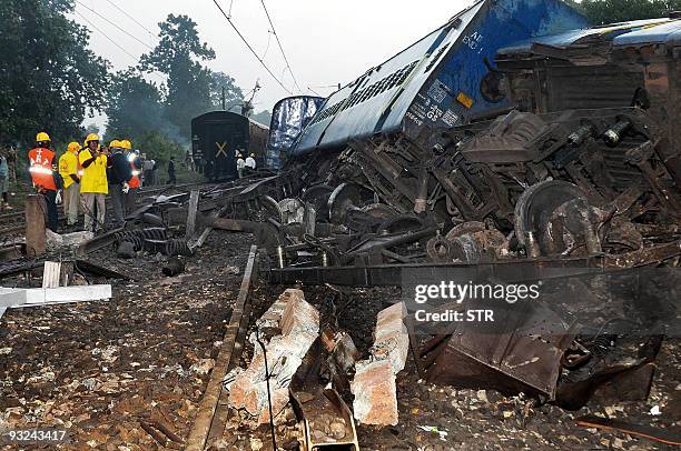 Rescue workers inspect the train carriages of the Tata-Bilaspur Passenger express derailed after Maoist rebels blew up the railway tracks near the...