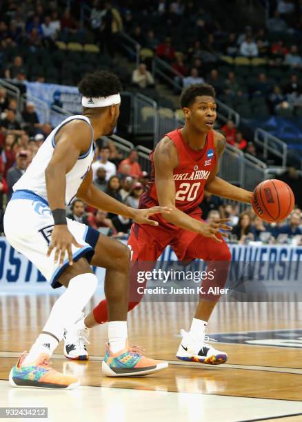 Kameron McGusty the Oklahoma Sooners is defended by E.C. Matthews of the Rhode Island Rams during the first round of the 2018 NCAA Men's Basketball...