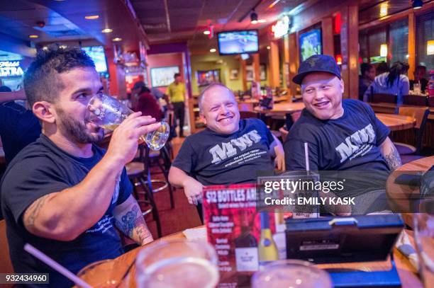 Eddie Piedra, left, Jamie Brooks, center, and Jacob Brooks, right, enjoy beers and food at Applebees with the rest of the team after their show in...