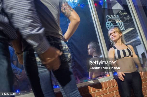 Show attendant grabs the behind of his partner while talking to BreAnnah Belliveau after the show at Johnson's Station in Picayune, Ms., on Feb. 11,...