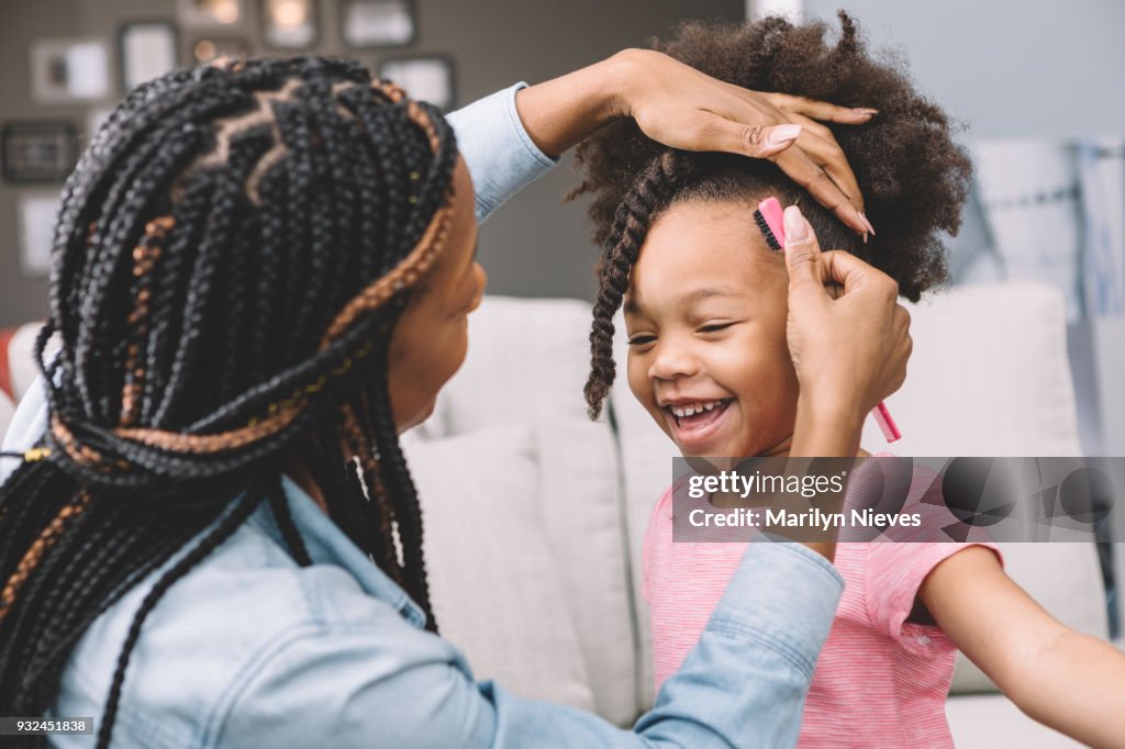 Mother styling daughter's curly hair