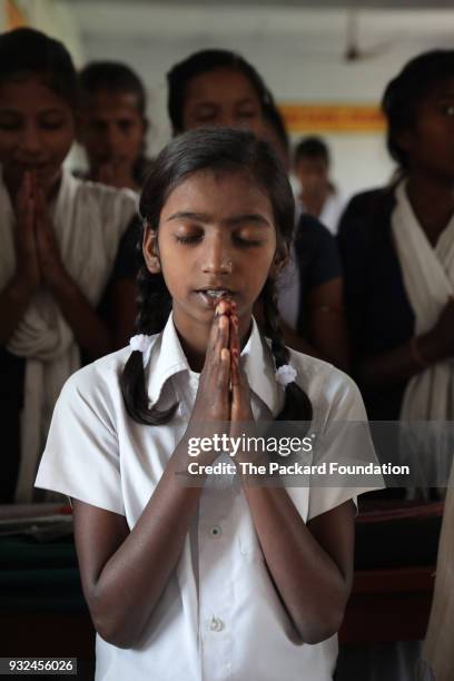 Seventh grade girls recite a prayer in the classroom. Teachers at the school deliver CorStone's Youth First program, an integrated emotional...