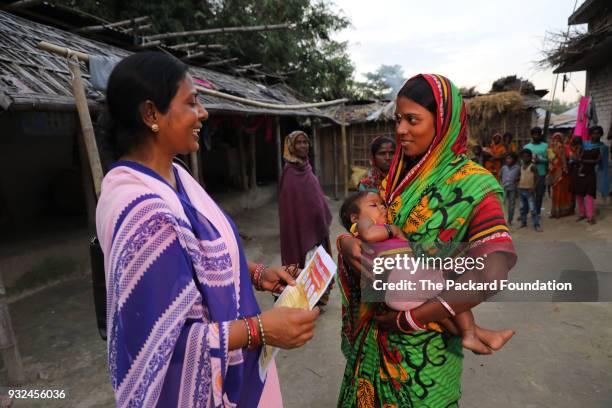 An Accredited Social Health Activist interacts with a young mother during a home visit. ASHAs are trained and supported by Pathfinder International...