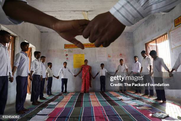 Classroom of boys at Middle School Keoti Balak hold hands in the "Opening Circle" of their Youth First emotional resilience session, which is...