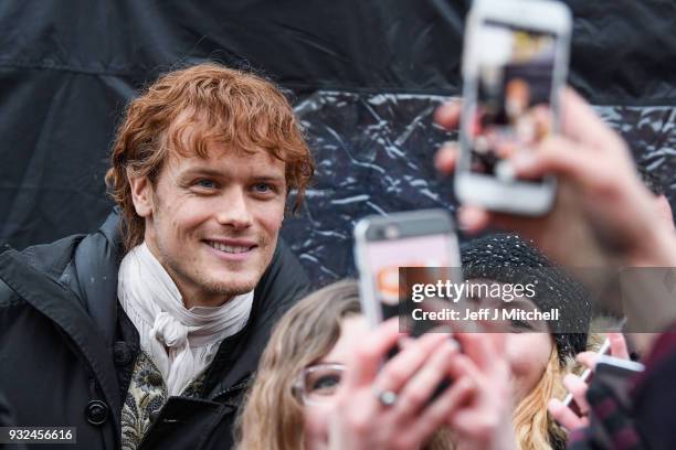 Sam Heughan from the TV series Outlander departs a filming location at St Andrew's Square on March 15, 2018 in Glasgow, Scotland. Dozens of fans have...