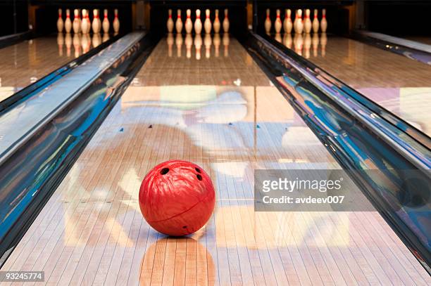 red bowling ball sitting in middle of newly oiled lane - bowls stock pictures, royalty-free photos & images