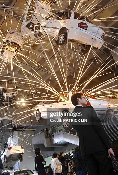 Visitors view vehicles suspended in mid-air at the Taipei Fine Arts Museum on November 20, 2009. The museum features an exhibition of works by...