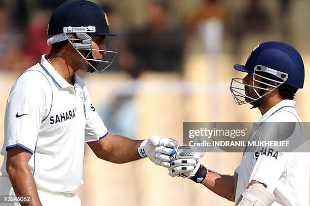 Indian cricketers VVS Laxman and Sachin Tendulkar bump fists on the fifth day of the first test between India and Sri Lanka at the Motera stadium in...