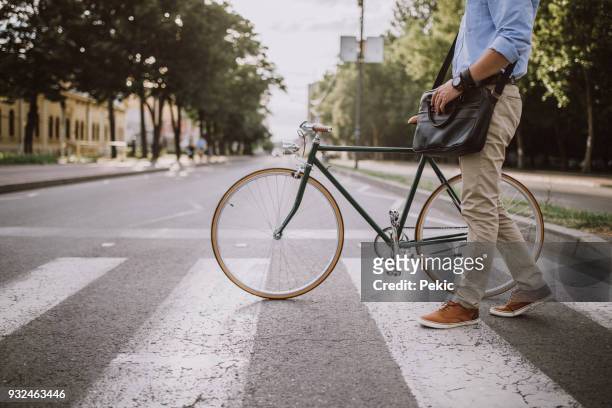 attraversare la strada con la bicicletta - city bike foto e immagini stock