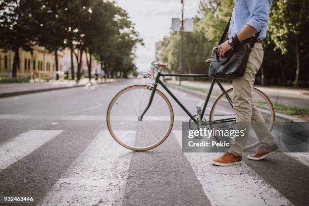 oversteken van de straat met de fiets - street worker stockfoto's en -beelden