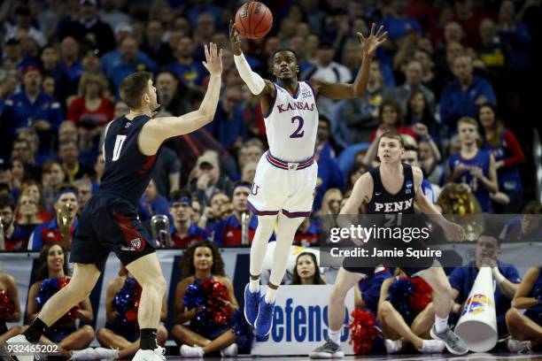 Lagerald Vick of the Kansas Jayhawks and Max Rothschild of the Pennsylvania Quakers reach for a loose ball in the first half during the first round...