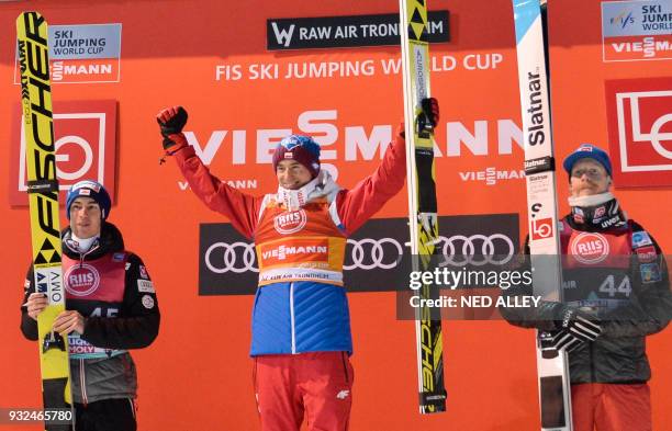 Second placed Stefan Kraft from Austria, winner Kamil Stoch from Poland and third placed Robert Johansson form Norway celebrate on the podium after...