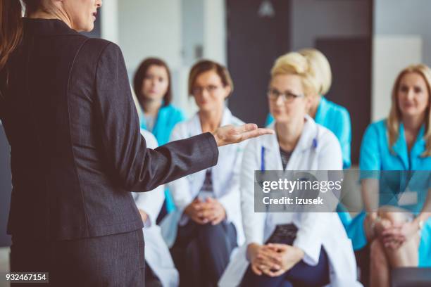 woman giving a speech on seminar for doctors - audience segmentation stock pictures, royalty-free photos & images