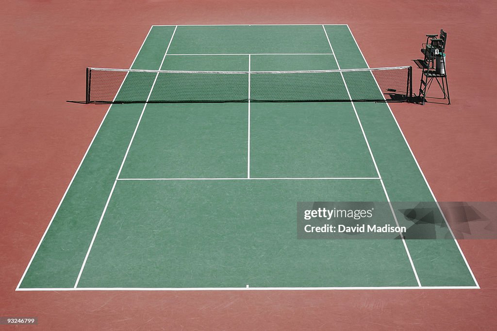 Empty tennis court and umpire's chair.