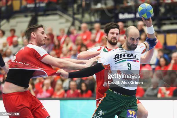 Joao Ferraz of Wetzlar is challenged by Gunnar Dietrich and Jonathan Scholz of Ludwigshafen during the DKB HBL match between Die Eulen Ludwigshafen...