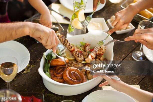 nemen aan bij familie picknick - plate in hand stockfoto's en -beelden