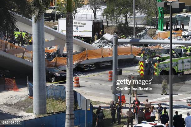 Vehicles are seen trapped under the collapsed pedestrian bridge that was newly built over southwest 8th street allowing people to bypass the busy...