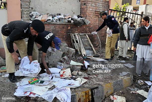 Pakistani police officials examine the site of a suicide bomb blast in Peshawar on November 19, 2009. A suicide bomber struck outside a Pakistan...