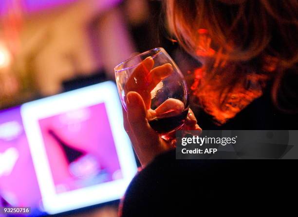 Chinese wine lover enjoys a glass of Beaujolais Nouveau at a Beaujolais party in Beijing on November 19, 2009. Beaujolais Nouveau, which flies off...