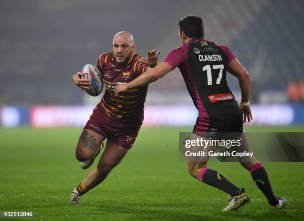 Dale Ferguson of Huddersfield Giants is tackled by Danny McGuire of Hull KR during the Betfred Super League match between Huddersfield Giants and...