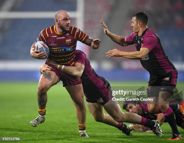 Dale Ferguson of Huddersfield Giants is tackled by Andrew Heffernan and Danny McGuire of Hull KR during the Betfred Super League match between...