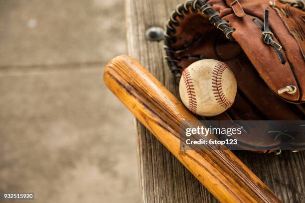 saison de baseball est ici. bat, gant et boule sur le banc de l’étang-réservoir. - batte-de-baseball photos et images de collection