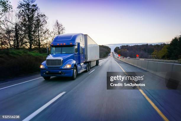 18 wheeler blue semi truck on highway at dusk - eld stockfoto's en -beelden