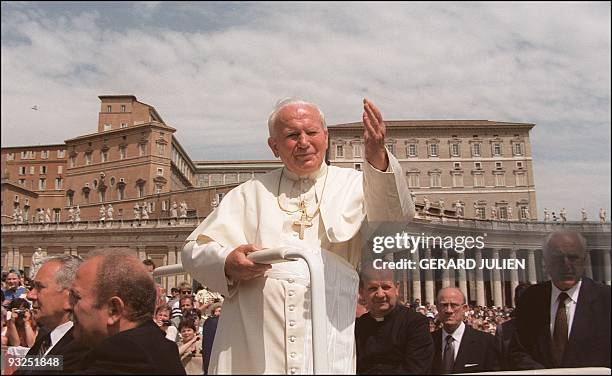 Pope John Paul II surrounded by his body-guards waves to faithful gathered at Saint-Peter' square in Vatican City 21 May 1997.