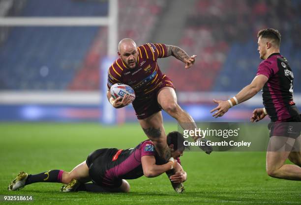 Dale Ferguson of Huddersfield Giants is tackled by Danny McGuire of Hull KR during the Betfred Super League match between Huddersfield Giants and...
