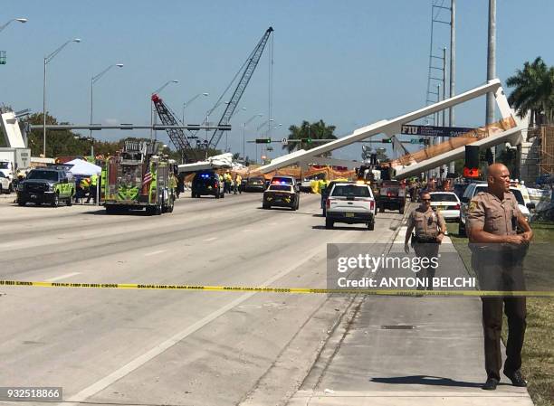 Police block a road near a newly installed pedestrian bridge, that collapsed, over a six-lane highway in Miami, Florida on March 15 crushing a number...