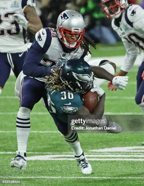 Jay Ajayi of the Philadelphia Eagles is hit by Stephon Gilmore of the New England Patriots during Super Bowl Lll at U.S. Bank Stadium on February 4,...