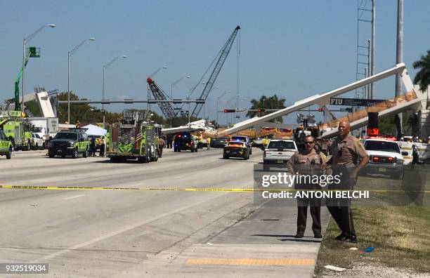 Police block a road near a newly installed pedestrian bridge, that collapsed, over a six-lane highway in Miami, Florida on March 15 crushing a number...
