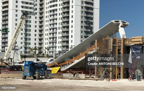 Crane is seen near a newly installed pedestrian bridge, that collapsed, over a six-lane highway in Miami, Florida on March 15 crushing a number of...