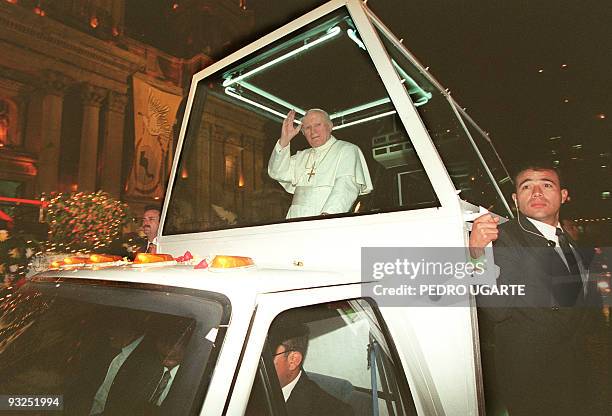 Pope John Paul II waves to people from the popemobile late 05 February 1996 upon his arrival in downtown Guatemala City. The pope will visit...